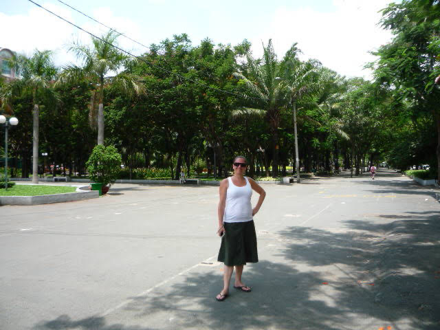 A large urban park with leafy trees and palm trees 