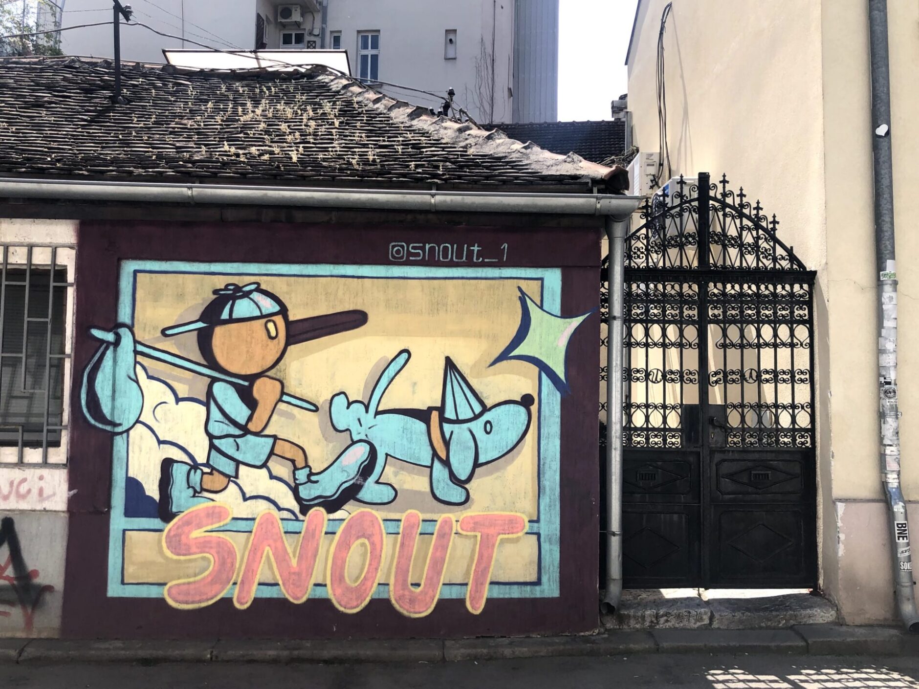 Mural of a boy wearing blue clothing carrying a blue sack while walking his blue dog