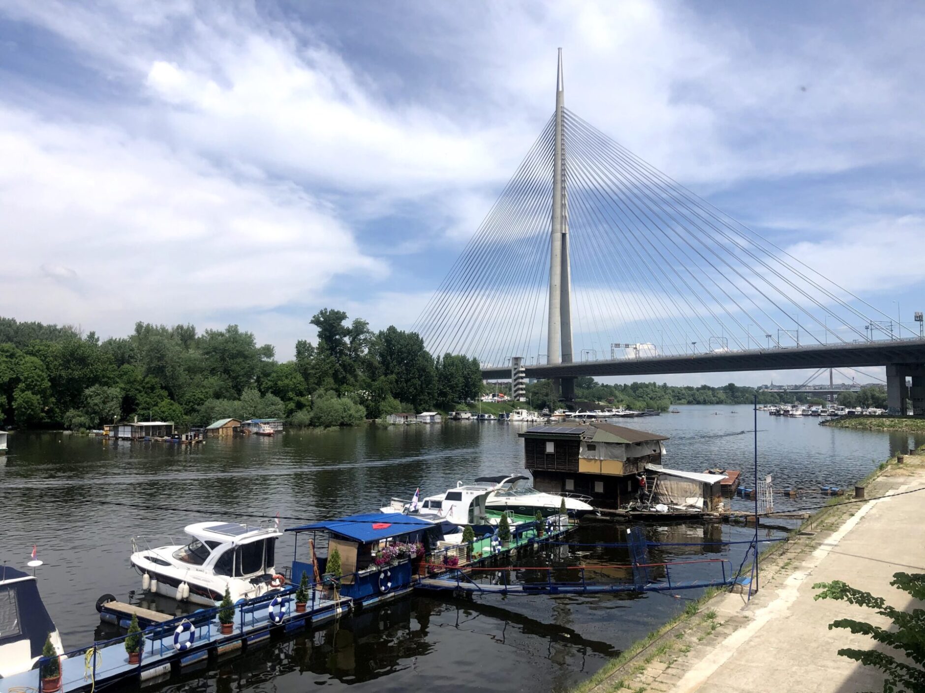 Small boats on a river with a pontoon bridge as the background