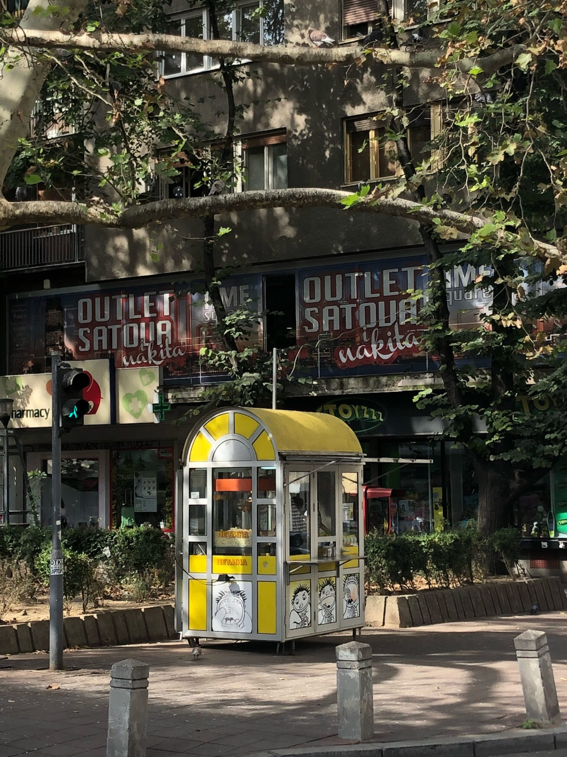 Yellow and white popcorn stand in a leafy park 