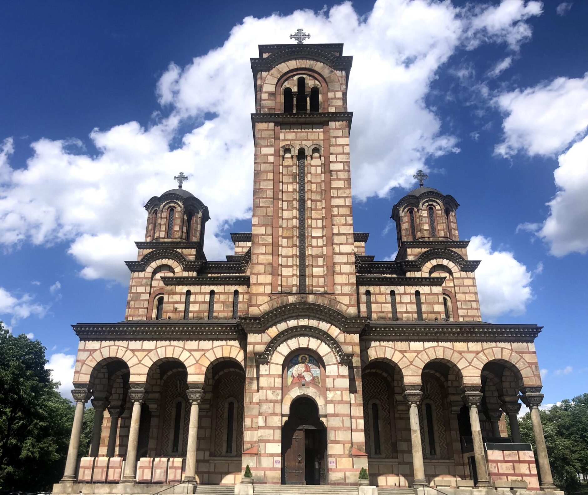 Brick facade of Saint-Mark’s Church with columns and a portico 