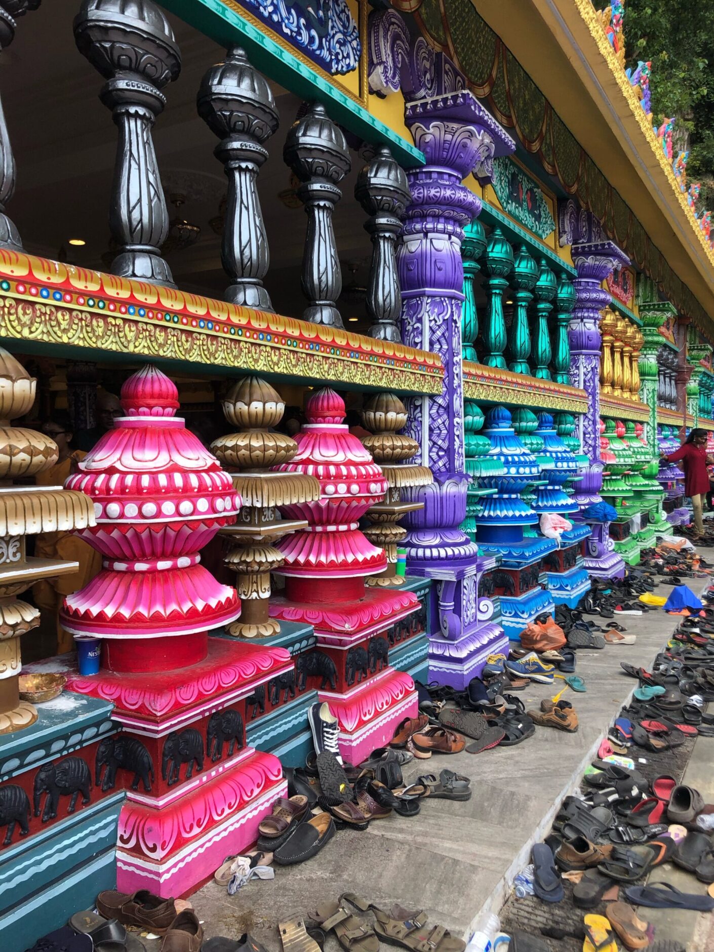 Piles of shoes along a row of colourful columns