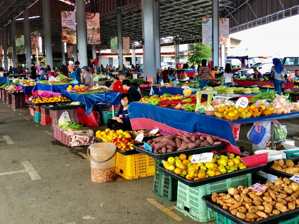 Vendor stalls filled with fresh fruits in an outdoor market