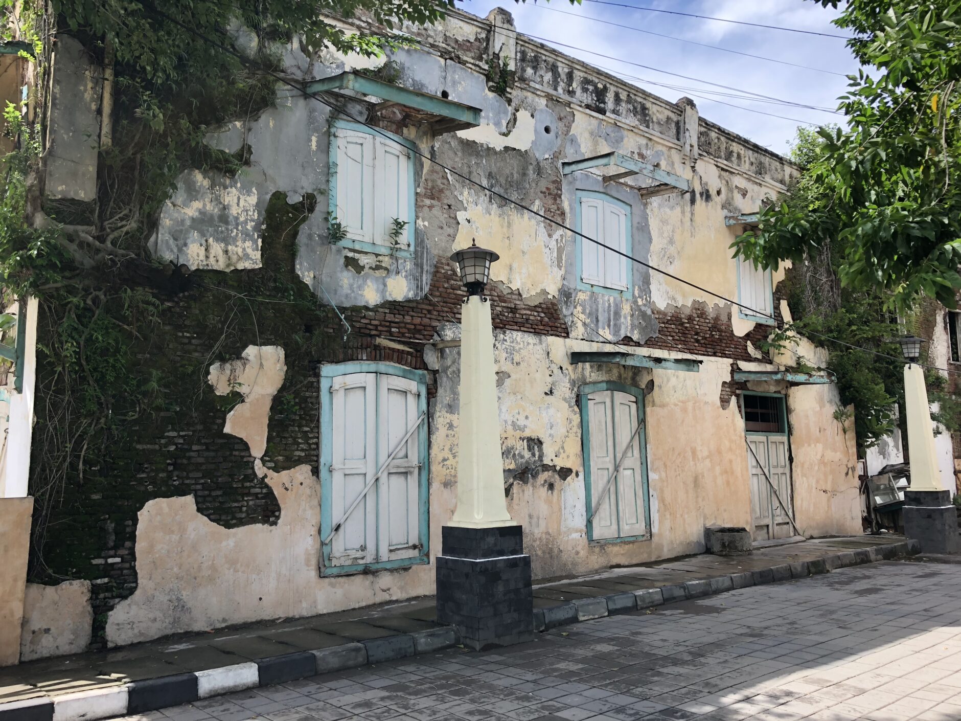 Decrepit Dutch building with blue and white shutters