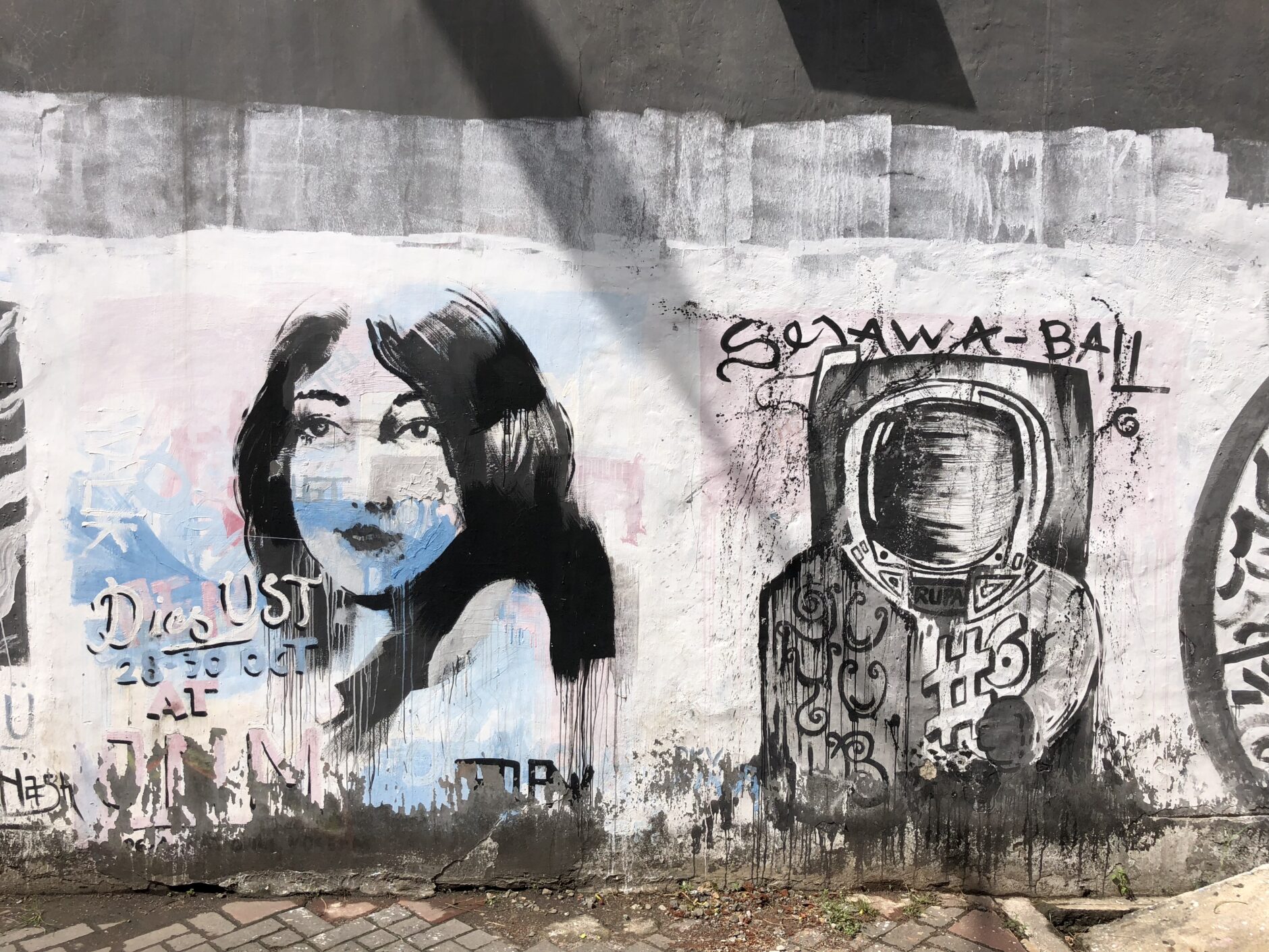 Black and white street art mural of a girl and an astronaut in the city of Semarang on the island of Java, Indonesia