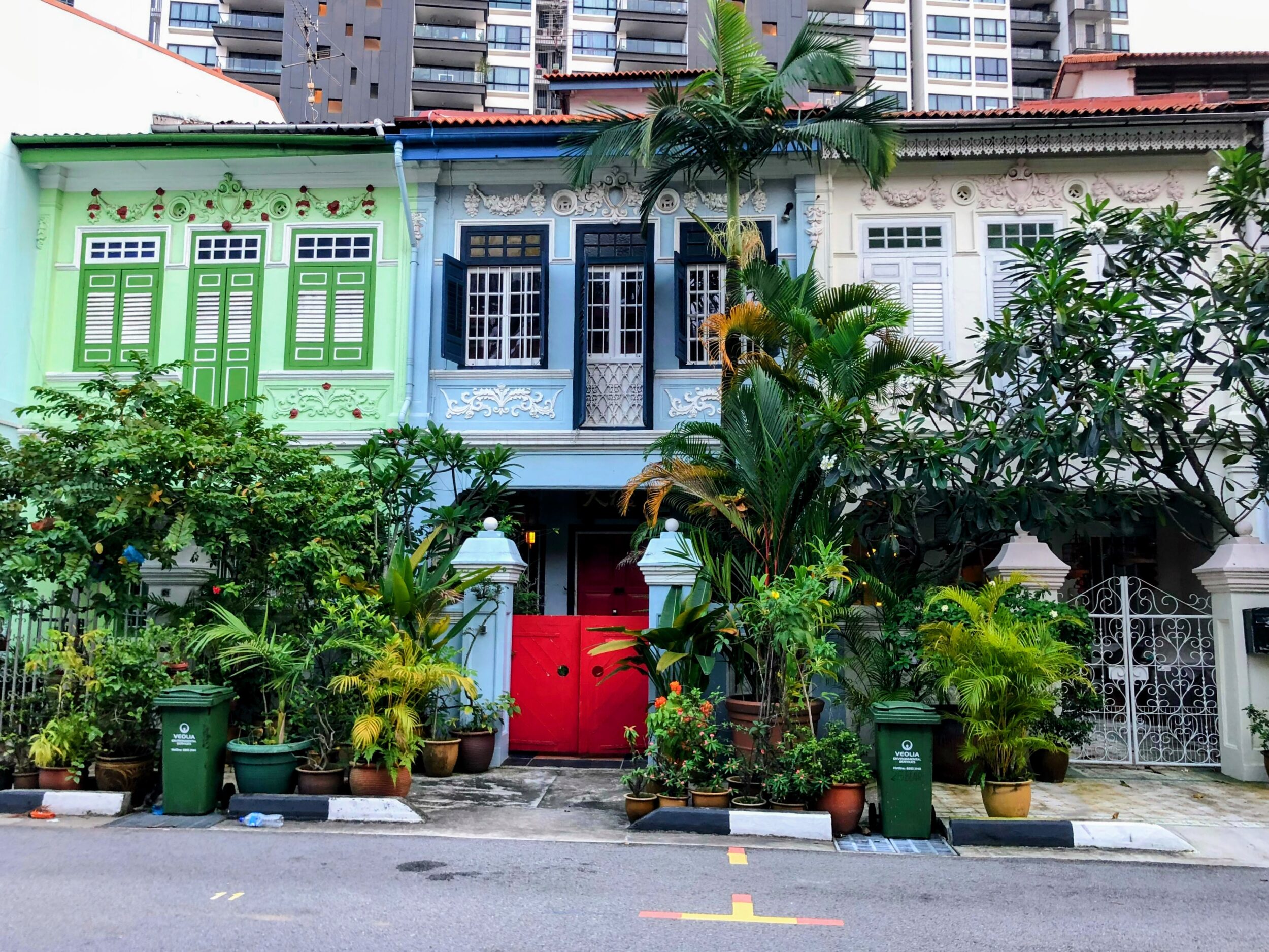 Blue and green ornate heritage terrace houses with shutters and green plants in Blair Conservation Area in Singapore