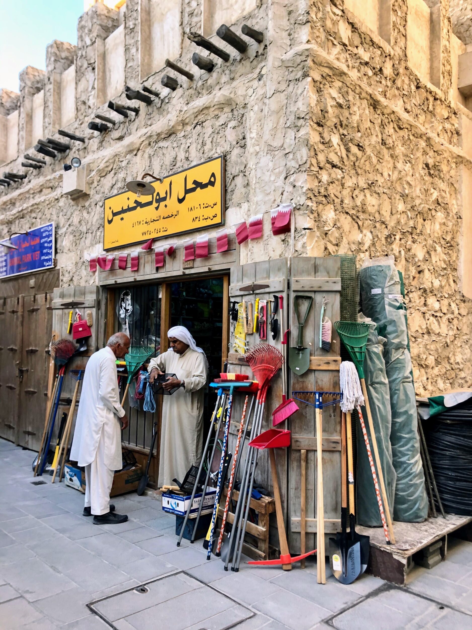 Elderly Qatari man wearing a white thobe at a hardware shop in Souq Waqif in Doha, Qatar