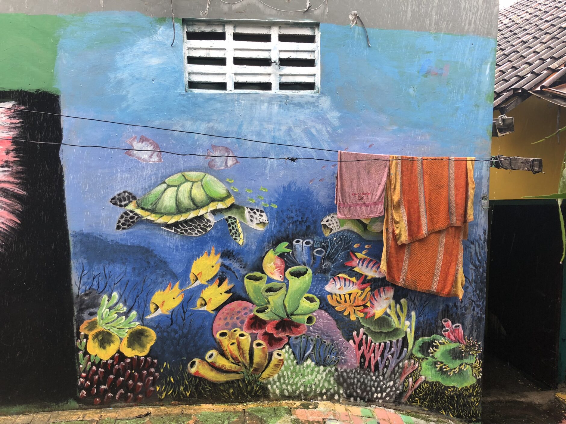 Mural depicting undersea life including a green turtle, small yellow fish and plants